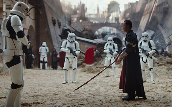 <i></noscript>Rogue One</i>„></div><p></p>
<p>Die Straßen des Planeten sind voller Priester, Glaubensmänner, heiligen Männern und Frauen. Ein Einwohner des Planeten wird als Kriegermönch bezeichnet – Chirrut Imwe, der von Donnie Yen gespielt wird – ein blinder Mann, der von seinem Beschützer und Begleiter Baze Malbuz (Jiang Wen) begleitet wird, der seinerseits nicht an übernatürliche Dinge glaubt und trotzdem tiefes Vertrauen in seinen Freund hegt.</p>
<p>Jedha ist außerdem die Heimatwelt von Bodhi Rook (Riz Ahmed), einem ehemals imperialen Pilot, der sich der wachsenden Widerstandsbewegung gegen Imperator Palpatine angeschlossen hat.</p>
<p>Mehr zu ihm und die Frage, warum er noch immer die imperialen Insignien auf seiner Schulter trägt, im Dienstagsbericht…</p></blockquote>
<input id=